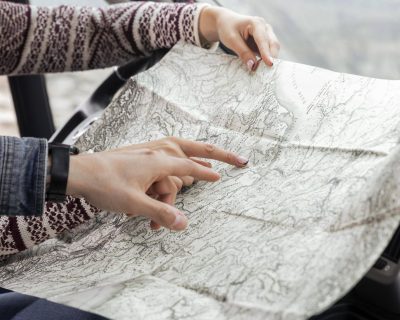 close-up-hands-pointing-map-scaled